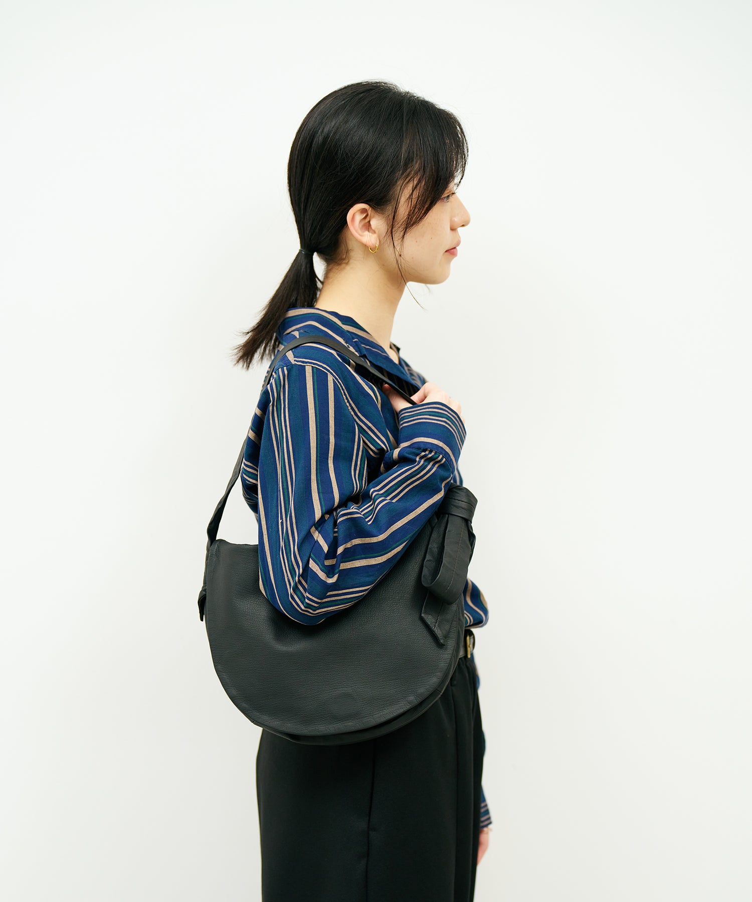 シンプルなサークル型ヤギ革ショルダーバッグ - フラップタイプの洗練